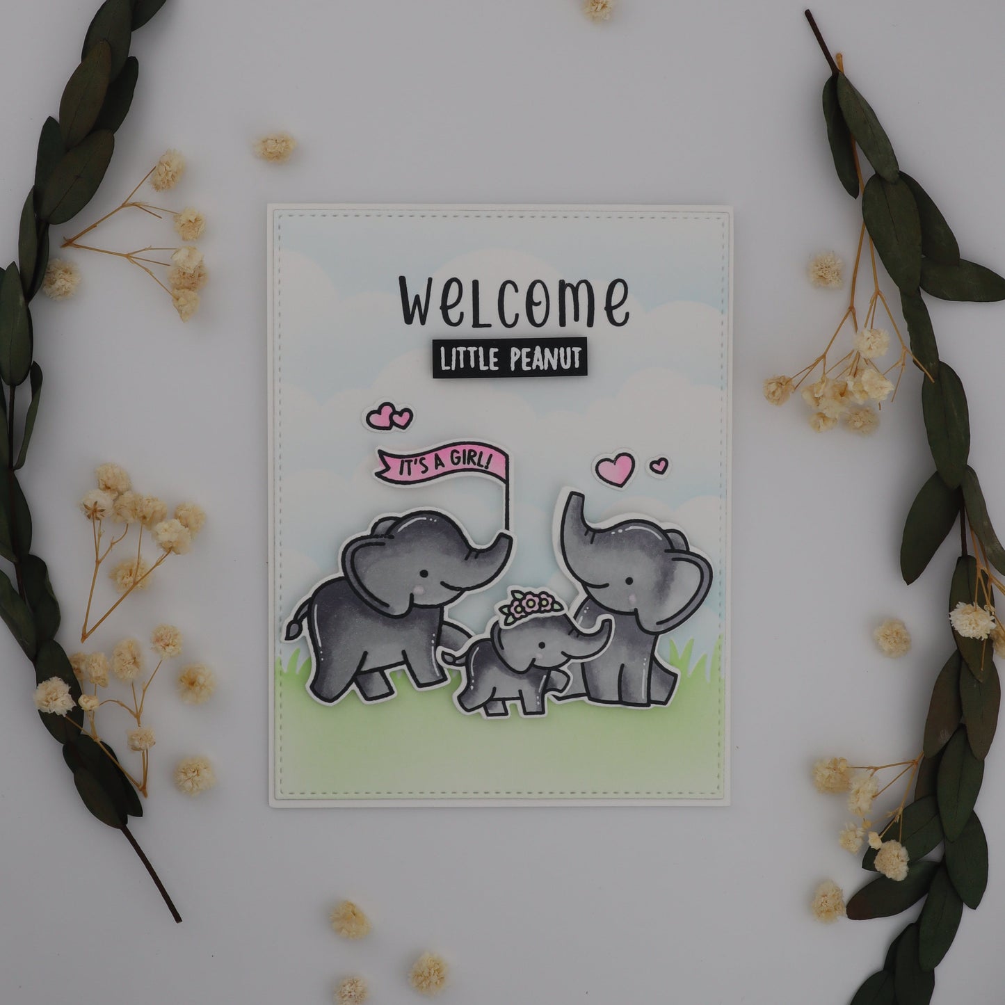 Card with elephants and text on a white background with decorative elements