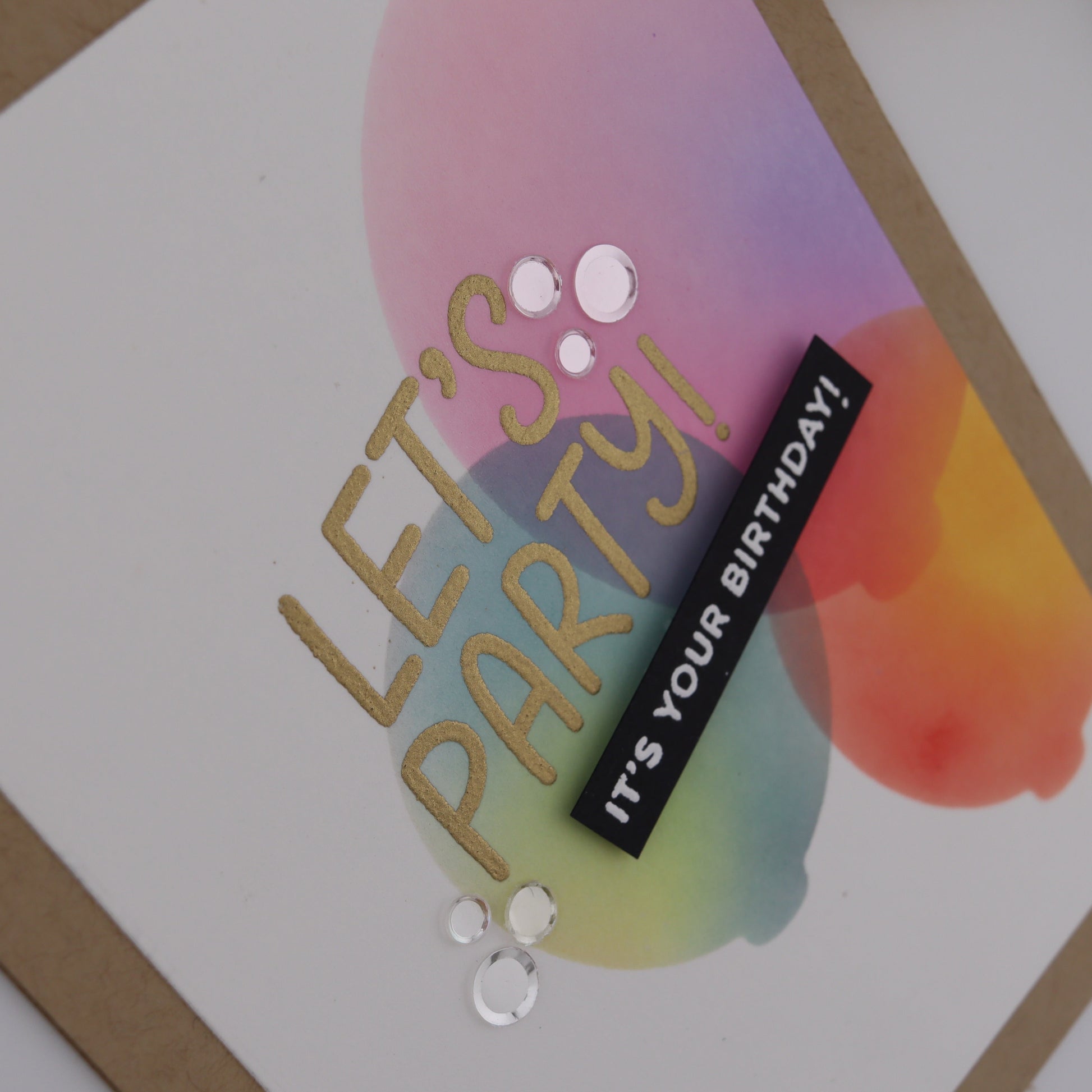 Greeting card with 'Let's Party! It's Your Birthday!' text and colorful design.