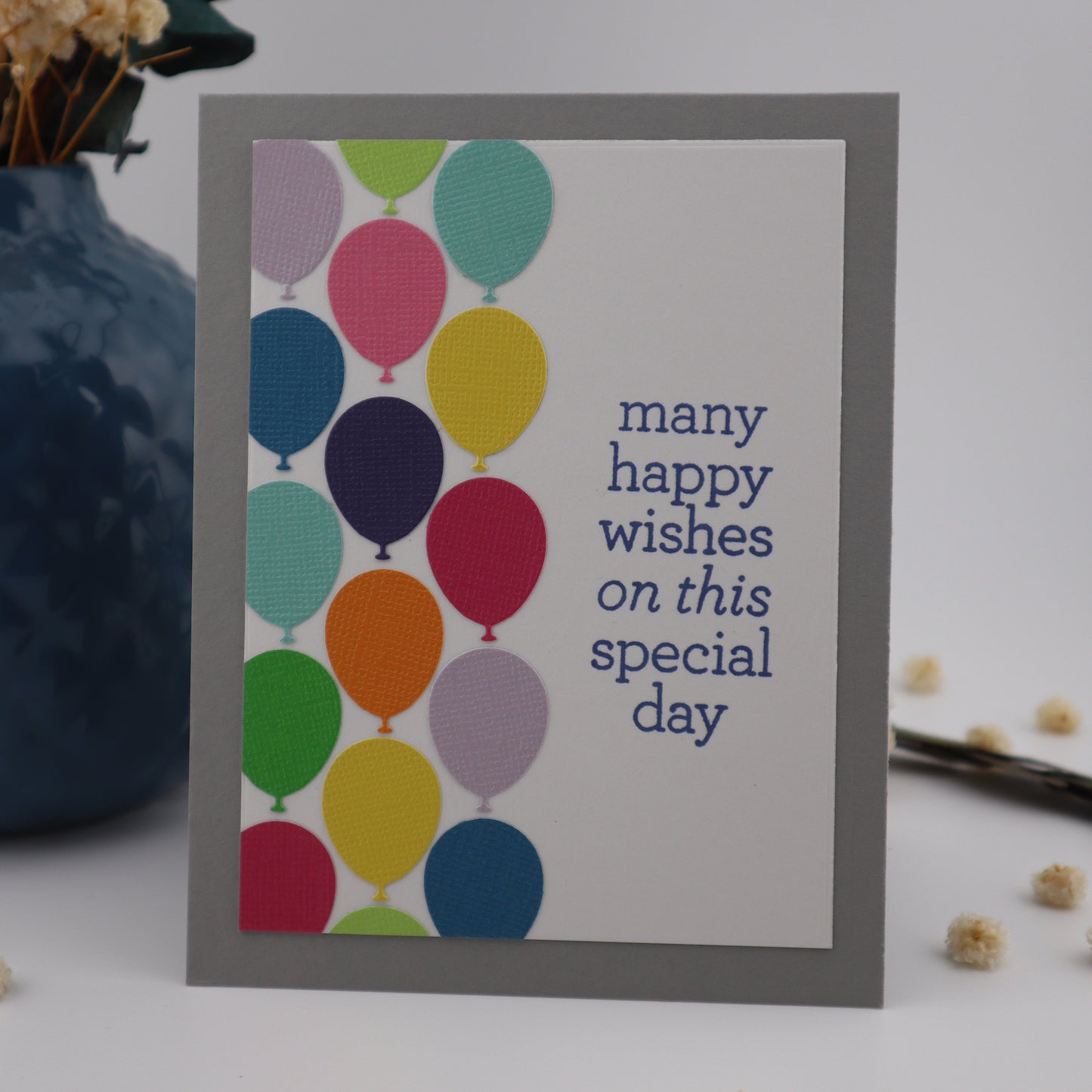 Greeting card with colorful balloons and text on a light background