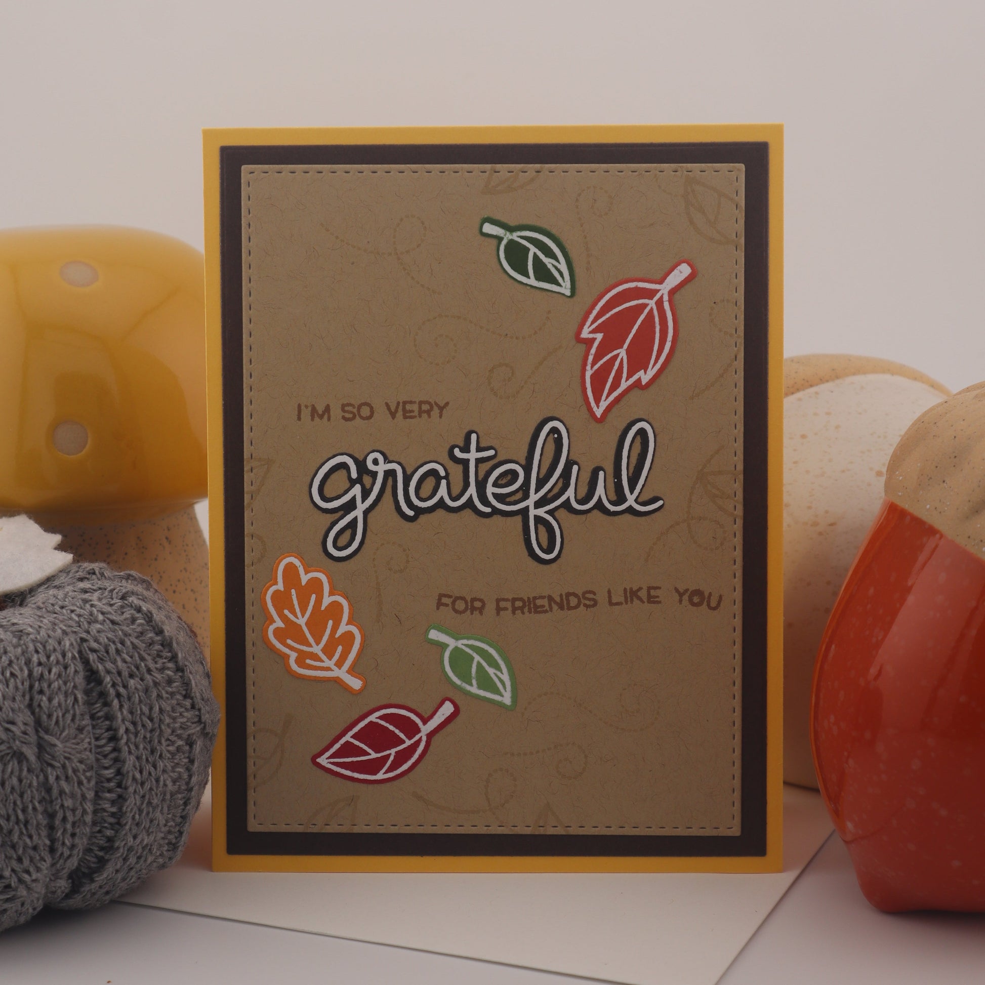 Card with 'grateful' text and autumn leaves on a white background
