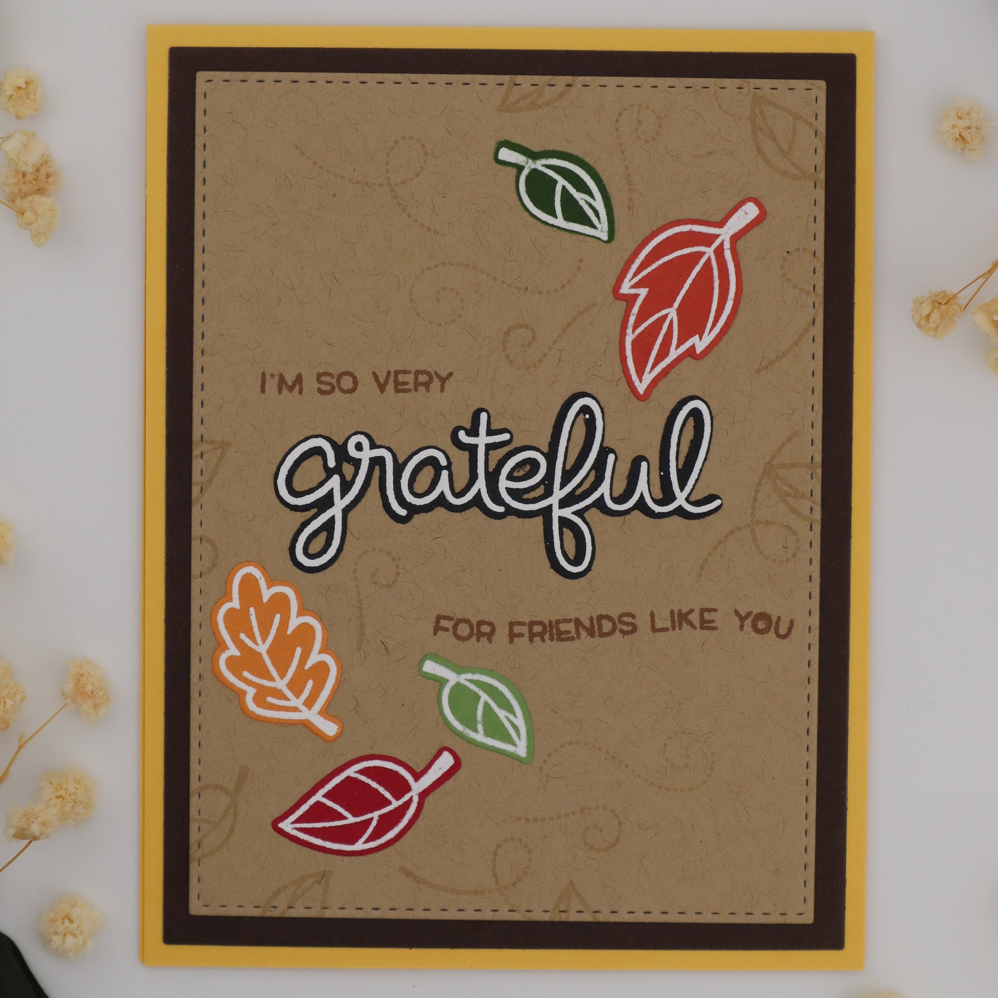 Card with 'I'm so very grateful for friends like you' text and leaf illustrations on a white background with flowers.