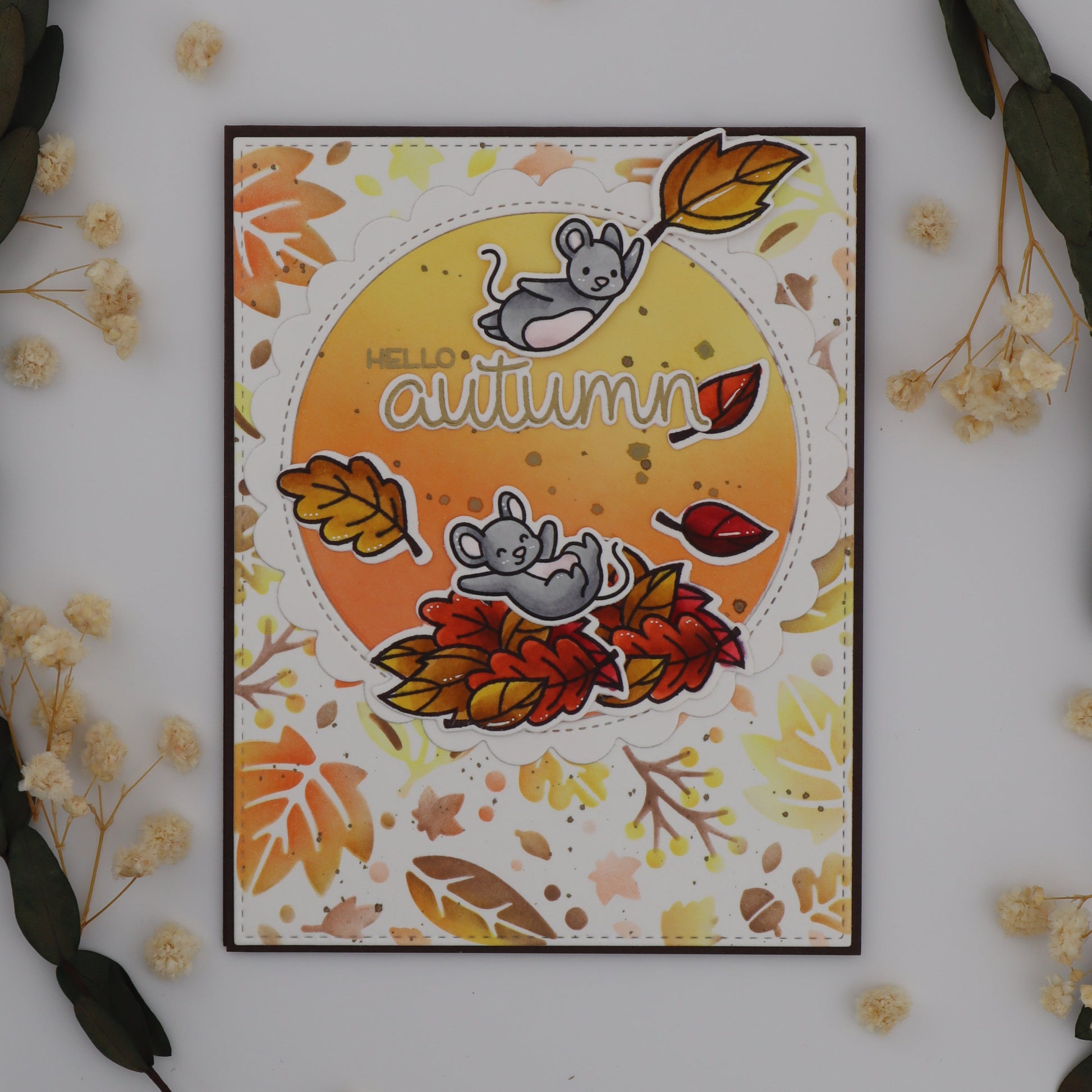 Autumn-themed card with leaves and flowers on a white background