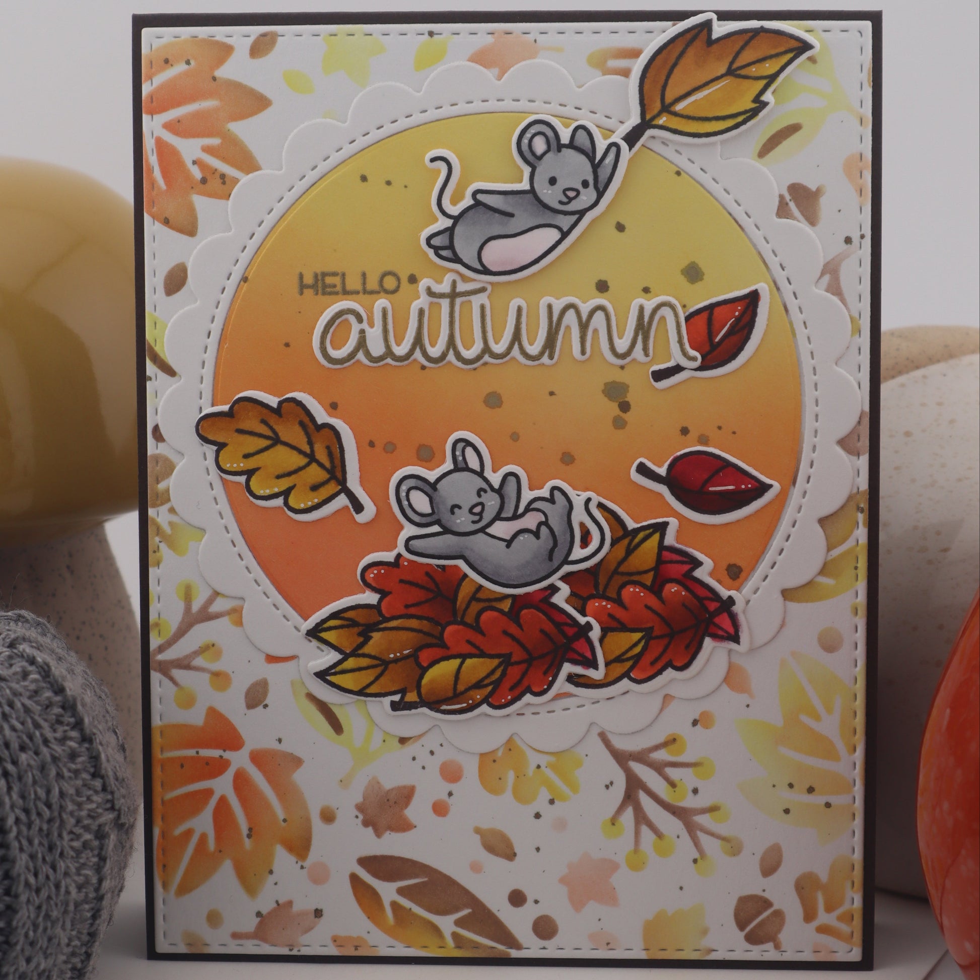 Autumn-themed card with leaves and mice design on a white surface.