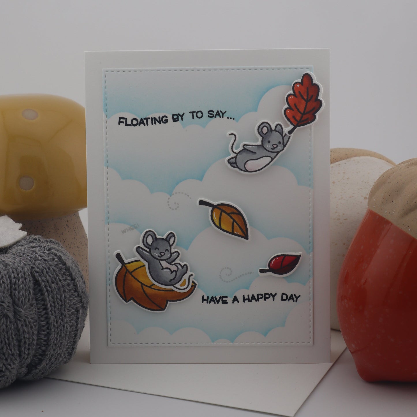 Card with cartoon elephants and autumn leaves on a white background