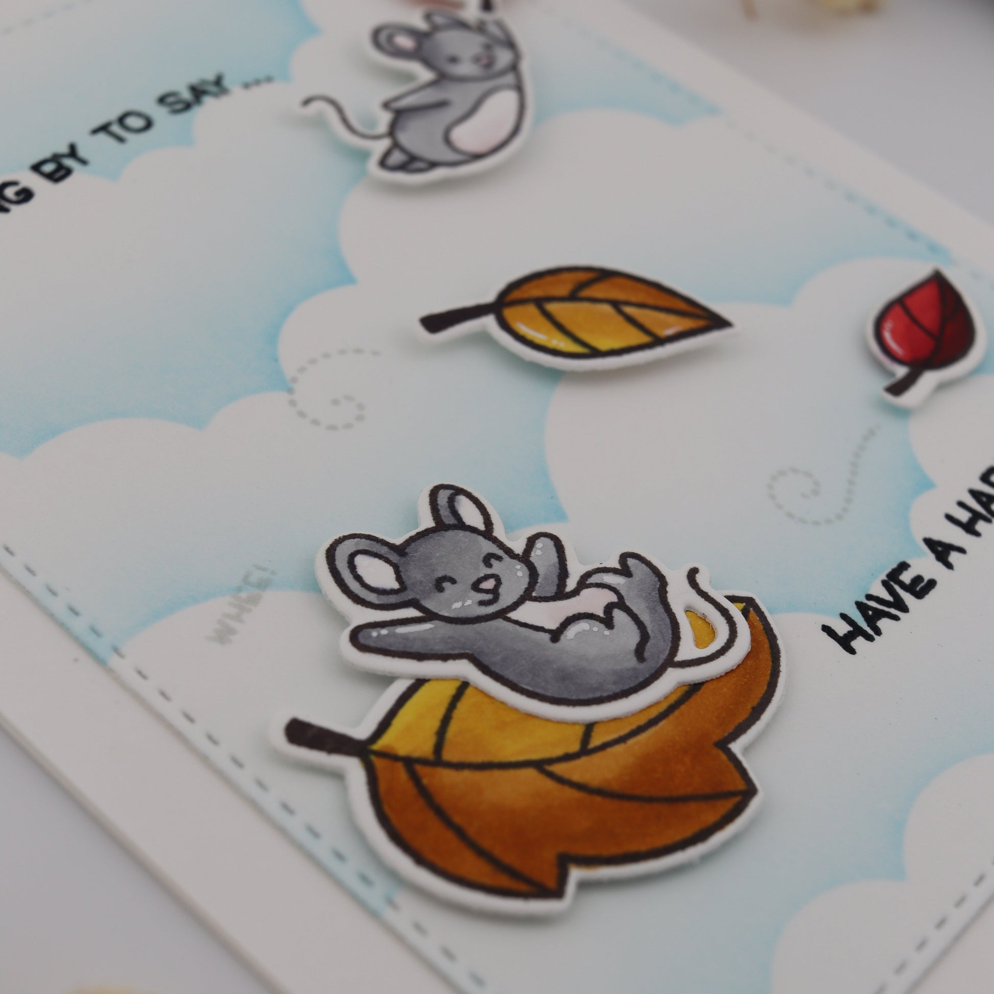 Cartoon mouse with autumn leaves on a card with 'Have a Happy Halloween' text.