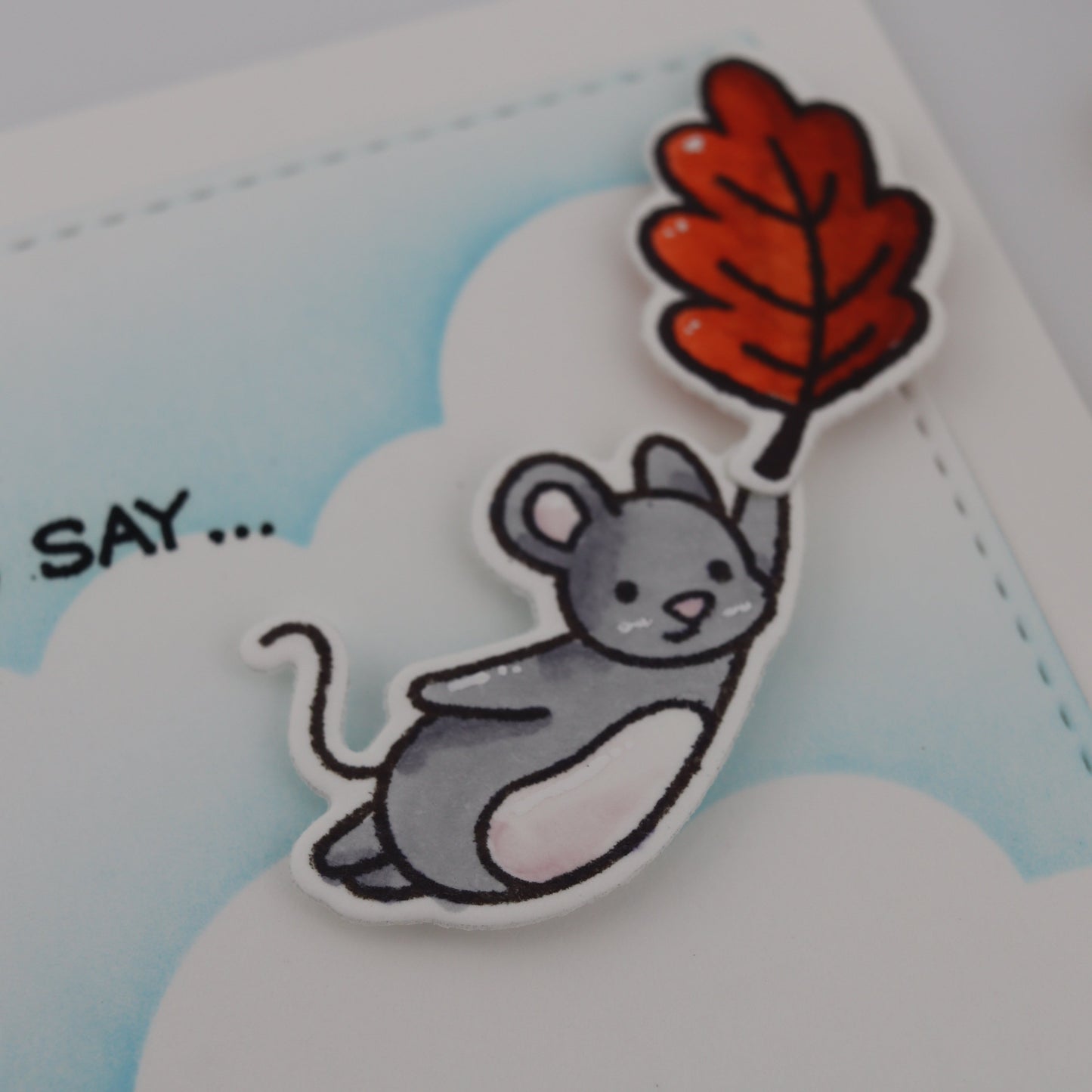 Cartoon mouse holding a red leaf with a blue background