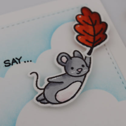 Cartoon mouse holding a red leaf with a blue background