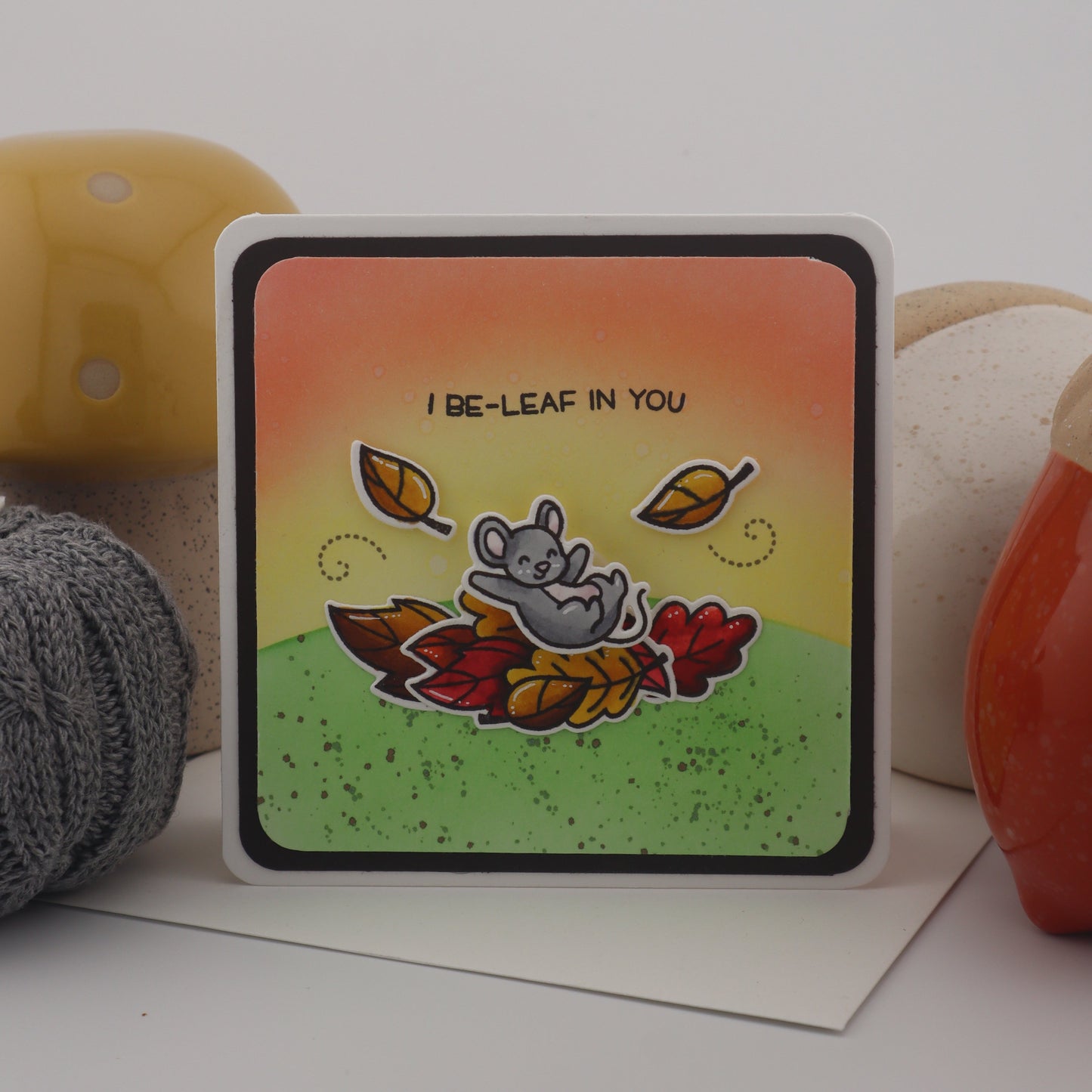 Colorful card with leaf design and text on a white surface