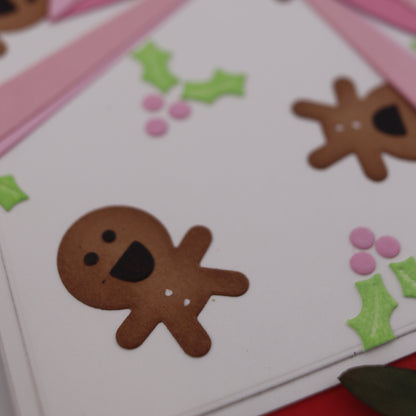 Decorative paper with gingerbread men and holly leaves on a white background