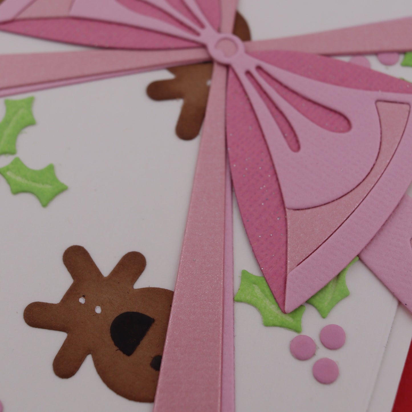 Close-up of a decorative card with pink ribbon and gingerbread men design.