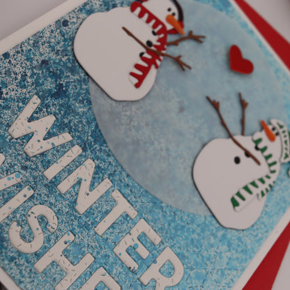 Card with snowmen and 'Winter Wishes' text on a blue background