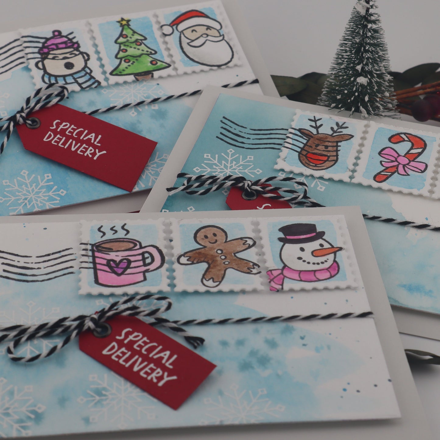 Set of Christmas-themed cards with stamps and decorative elements on a white surface.