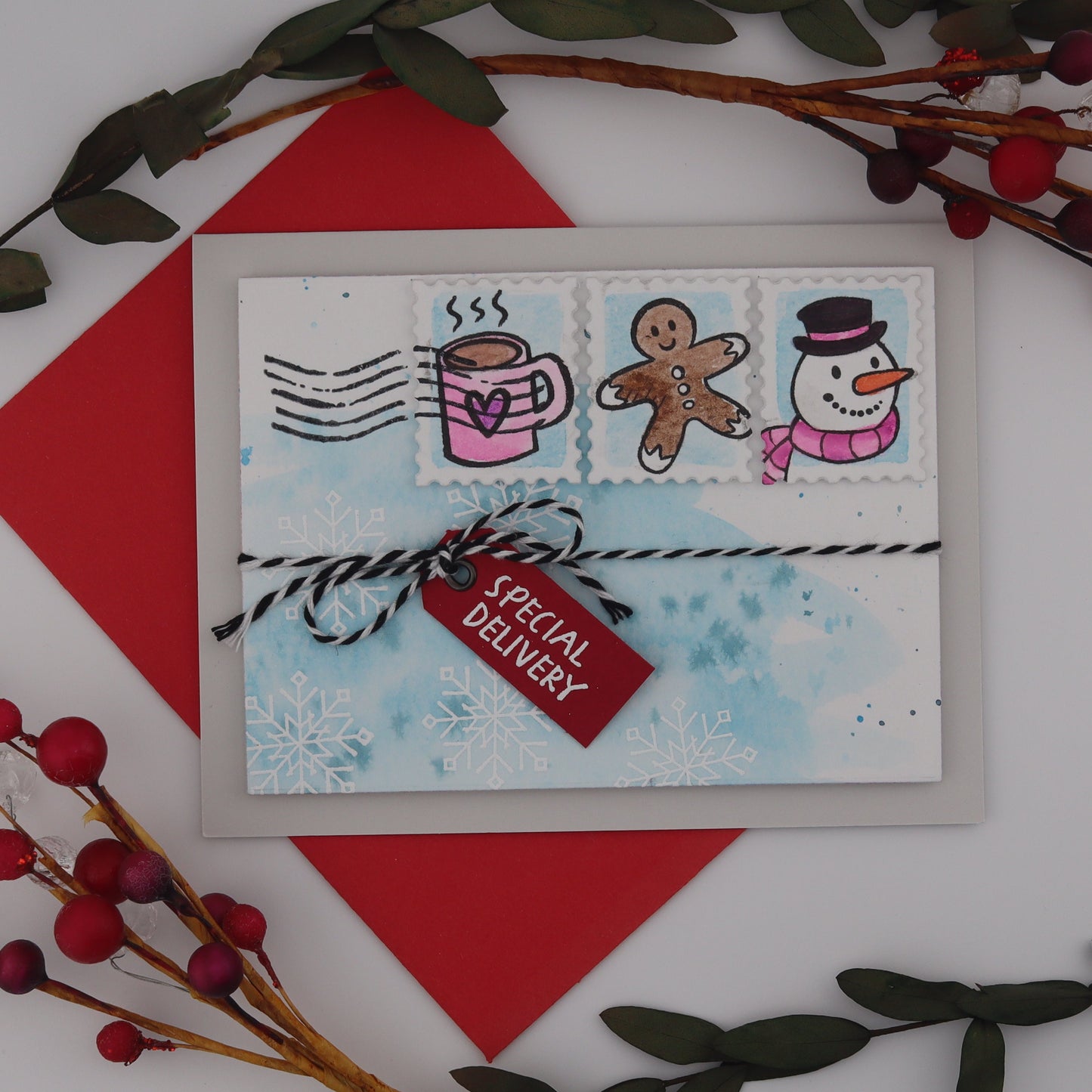 Christmas-themed card with red envelope and decorative elements on a white background