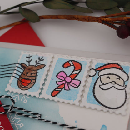 Decorative envelope with festive stamps featuring a reindeer, candy cane, and Santa Claus on a white background.