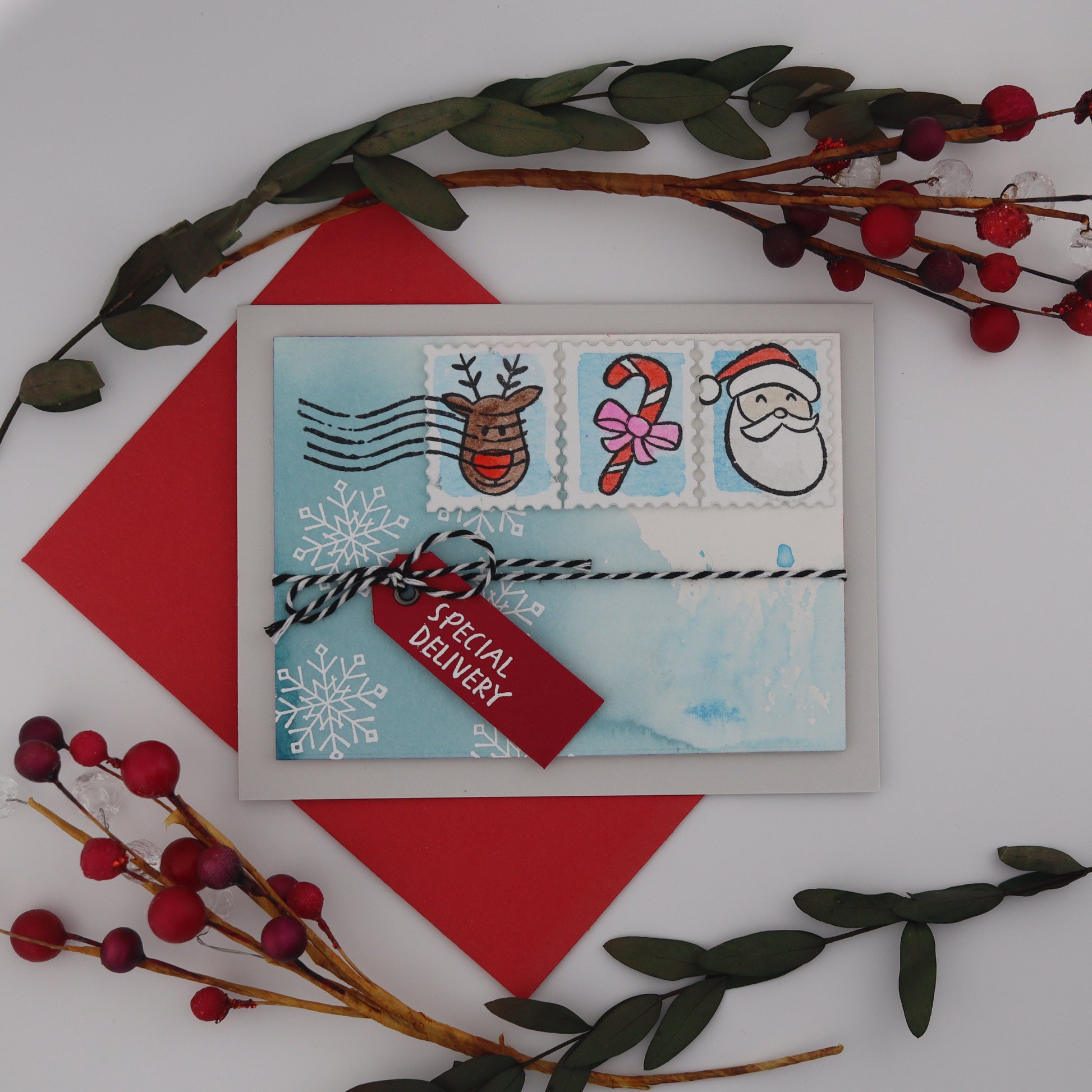 Christmas-themed card with stamps and a red triangle on a white background