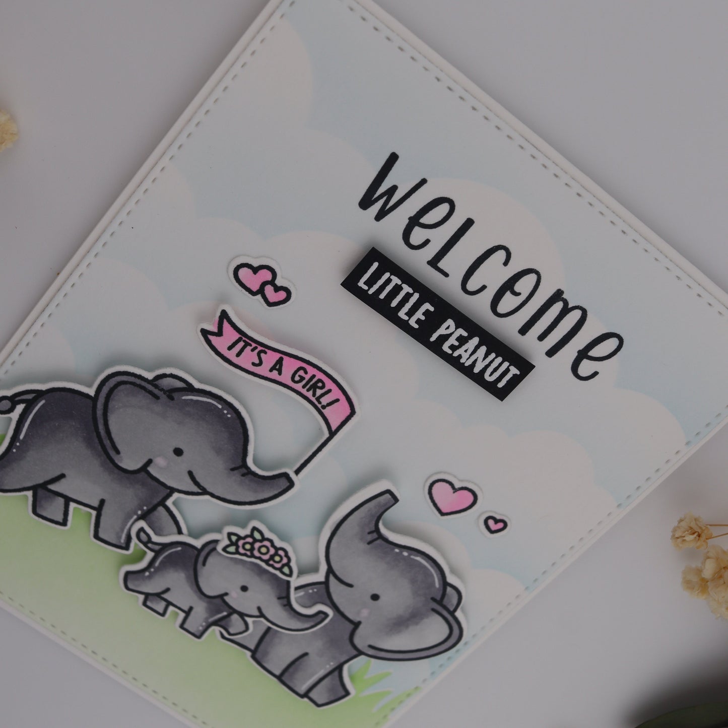 Baby shower card with elephants and 'Welcome Little Peanut' text on a light background