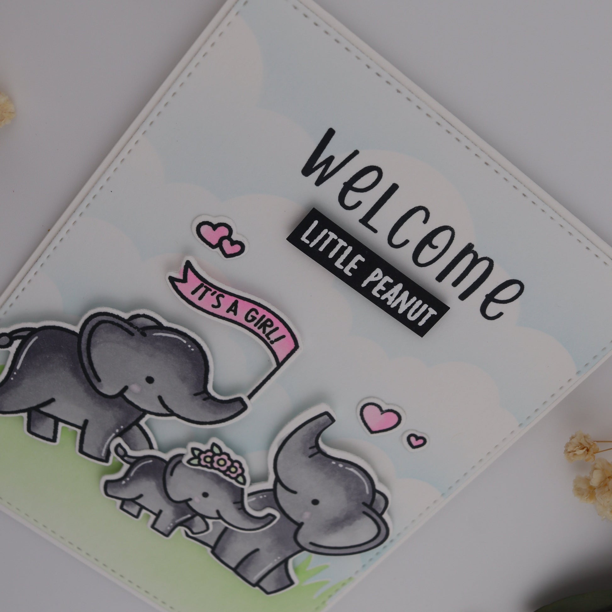 Baby shower card with elephants and 'Welcome Little Peanut' text on a light background
