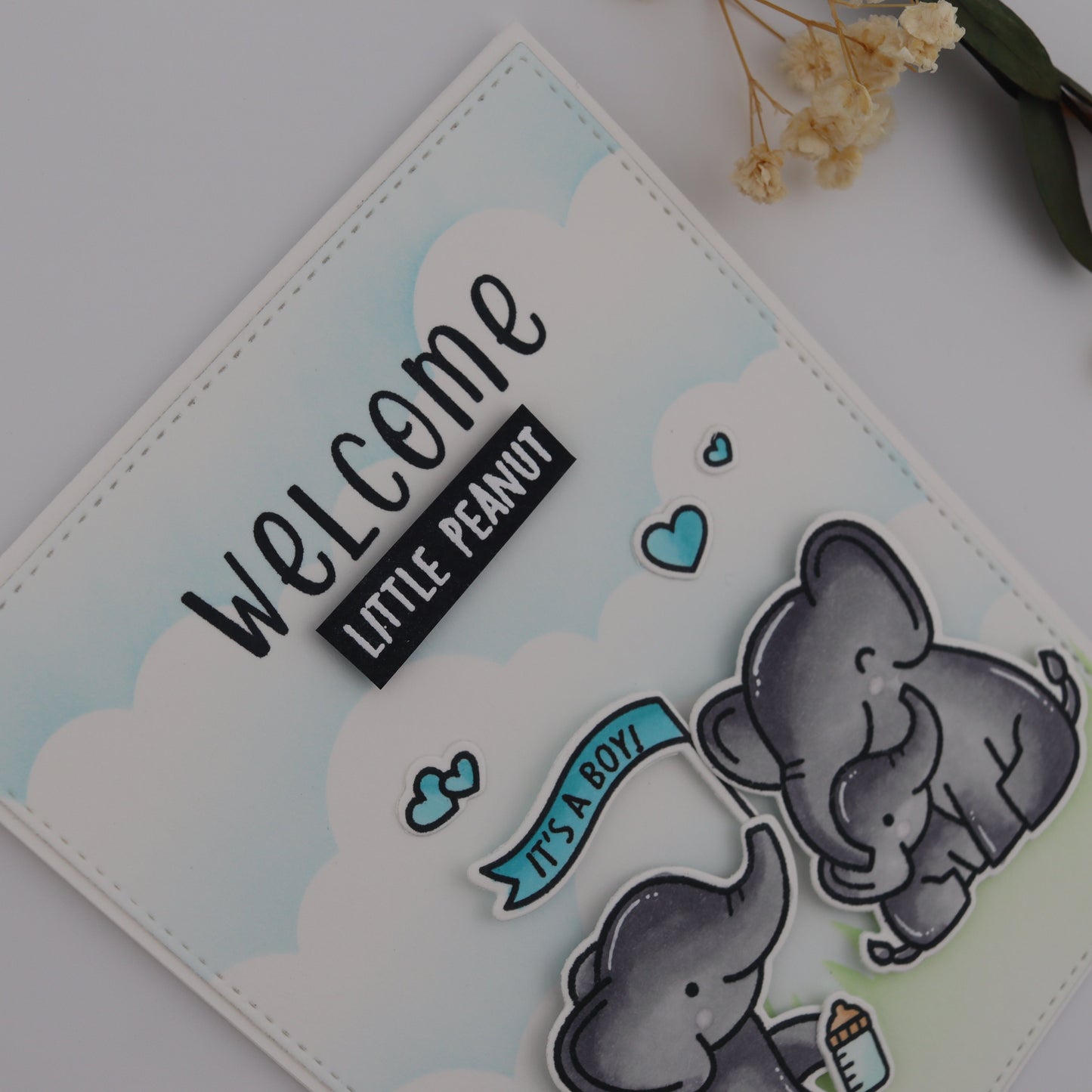 Card with two elephants and 'Welcome Little Peanut' text on a light background