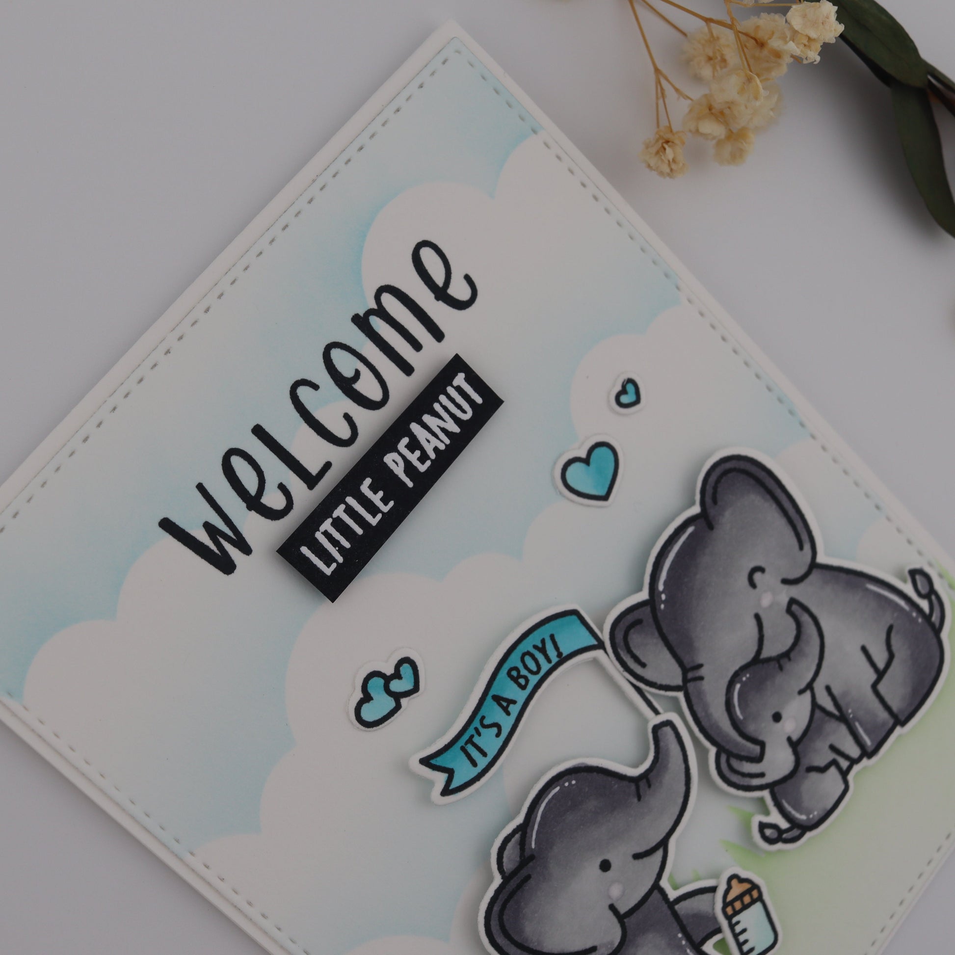 Card with two elephants and 'Welcome Little Peanut' text on a light background