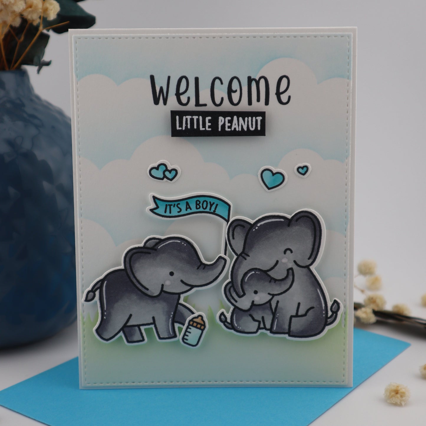 Card with elephant illustrations and 'Welcome Little Peanut' text on a light background