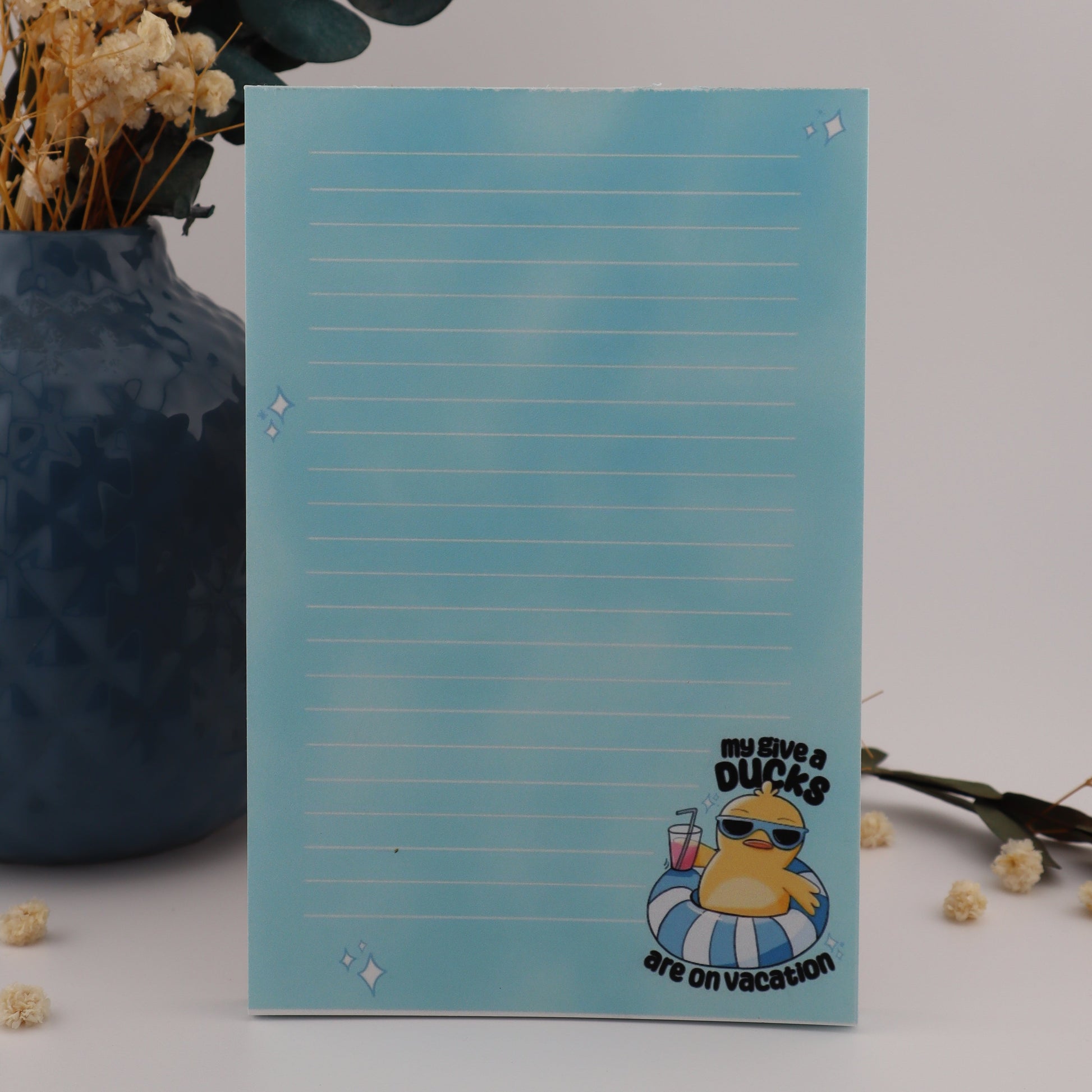 Notepad with cartoon character on a light gray background with decorative elements