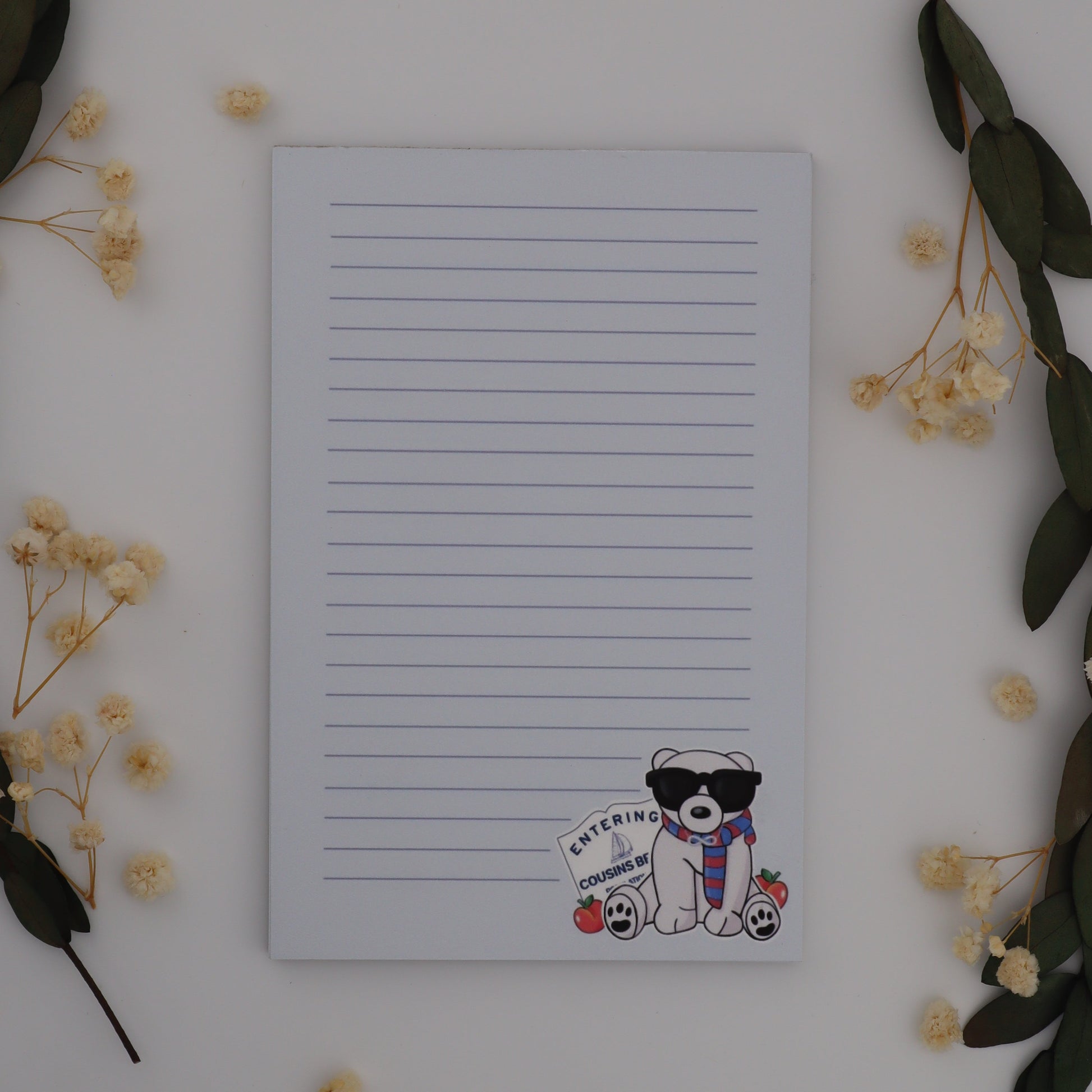 Notebook with a cute character sticker on a white surface with decorative elements