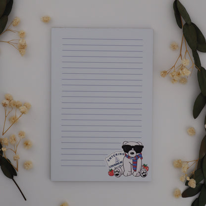 Notebook with a cute character sticker on a white surface with decorative elements