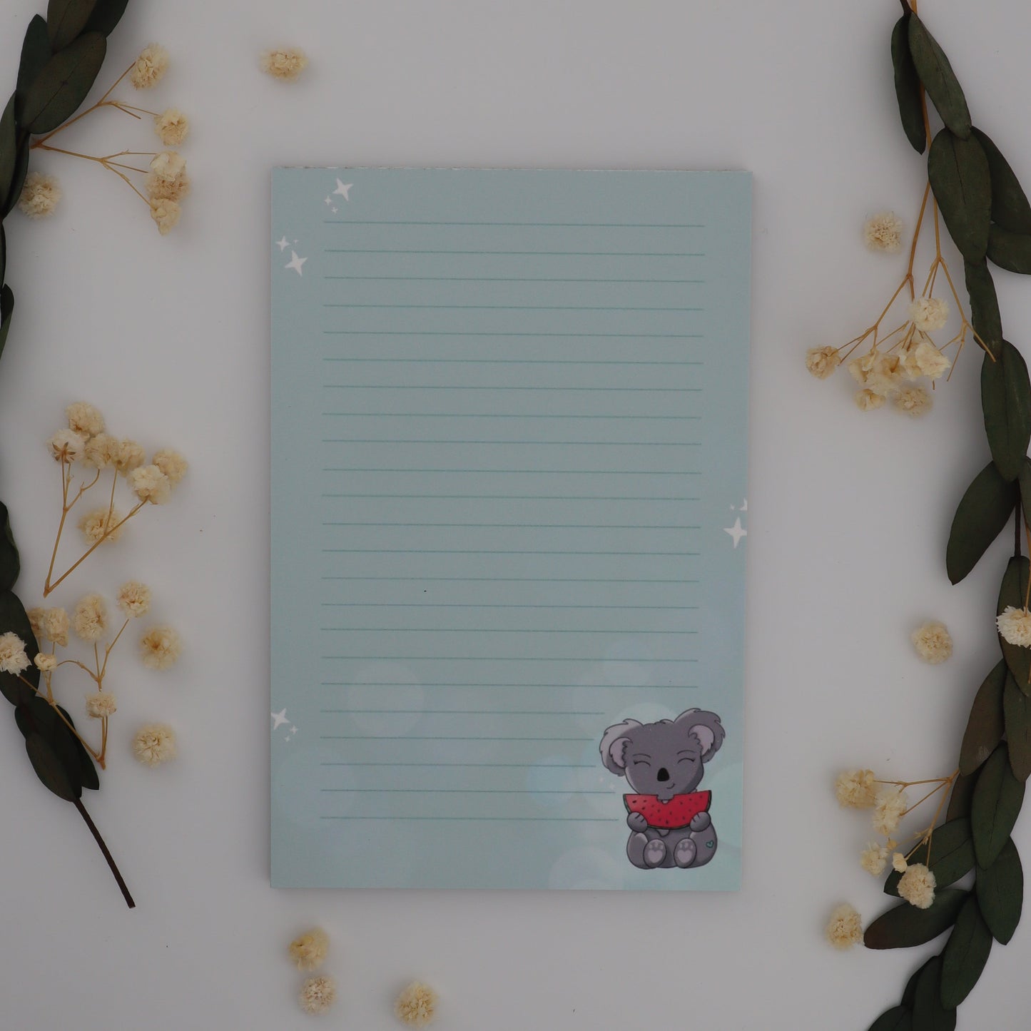 Notepad with a cartoon character on a white surface with decorative elements