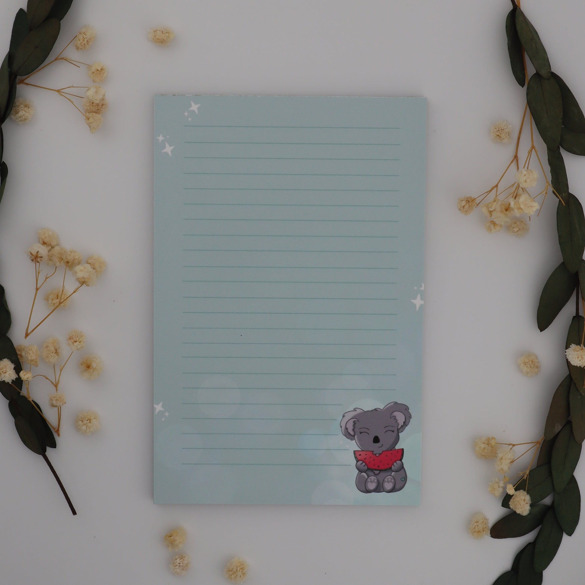Notepad with a cartoon character on a white surface with decorative elements