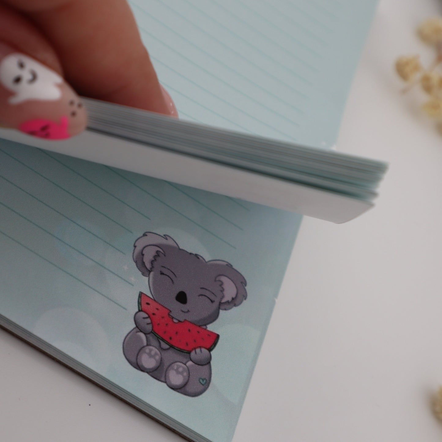 Notebook with a KOALA design held by a hand on a light background