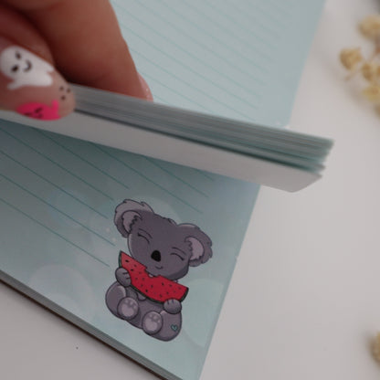 Notebook with a KOALA design held by a hand on a light background