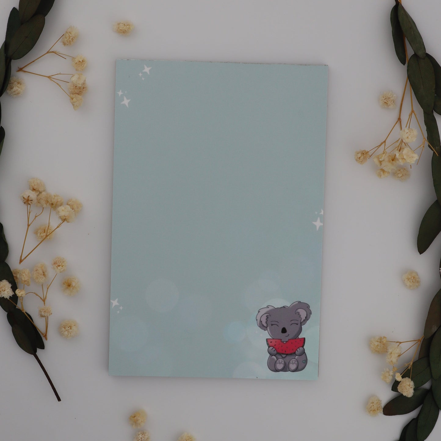 Notebook with a sticker on a white surface with decorative elements