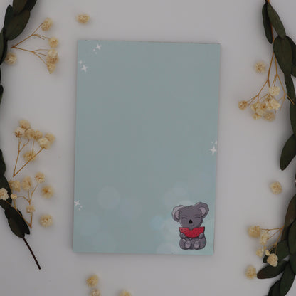 Notebook with a sticker on a white surface with decorative elements