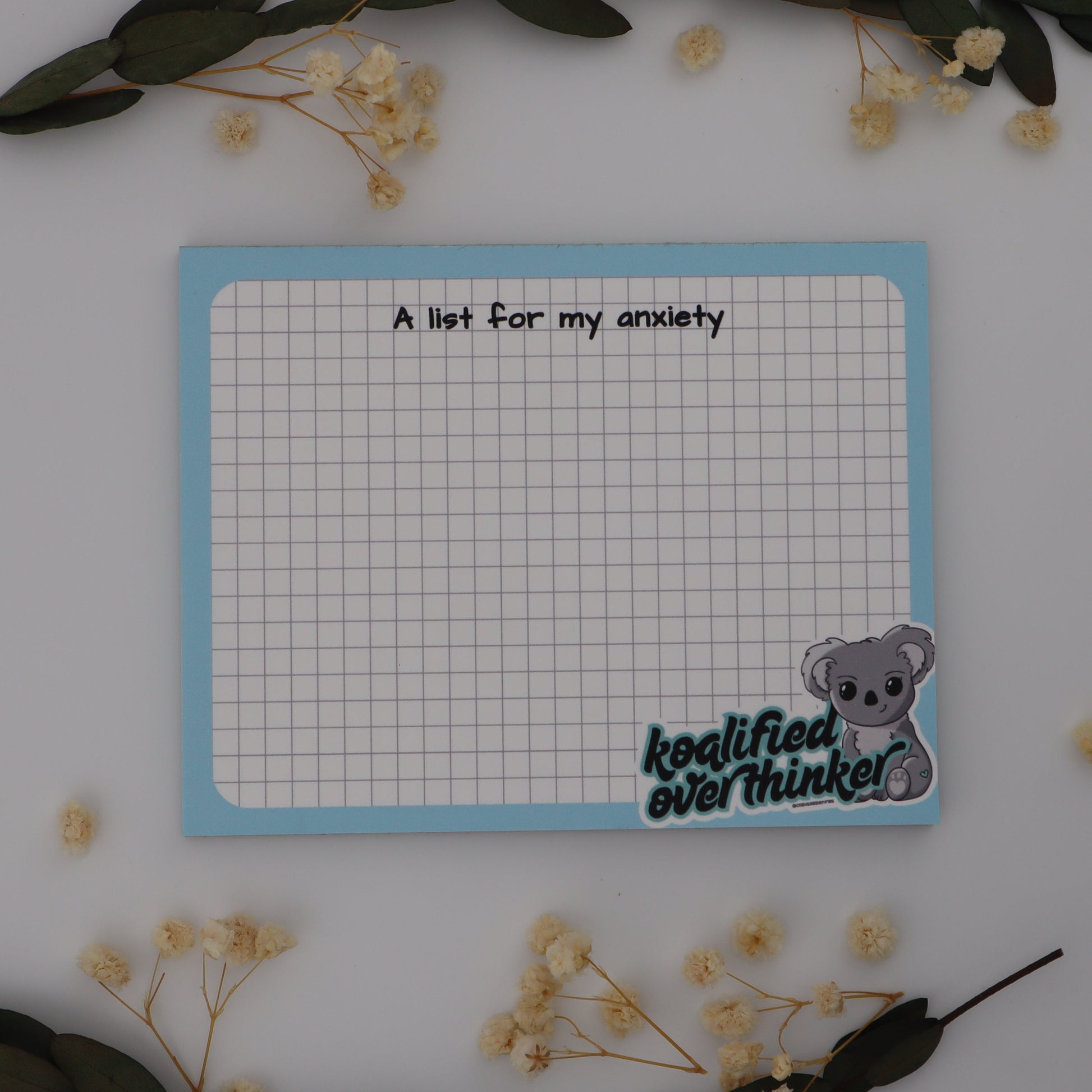 Notepad with a list titled 'A list for my anxiety' on a white background with decorative elements.