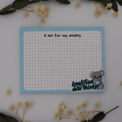 Notepad with a list titled 'A list for my anxiety' on a white background with decorative elements.