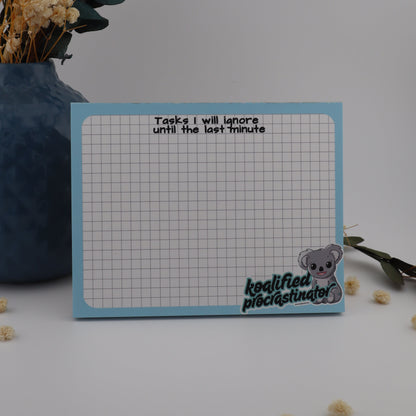 Notebook with grid pattern and text, placed on a surface with decorative elements.