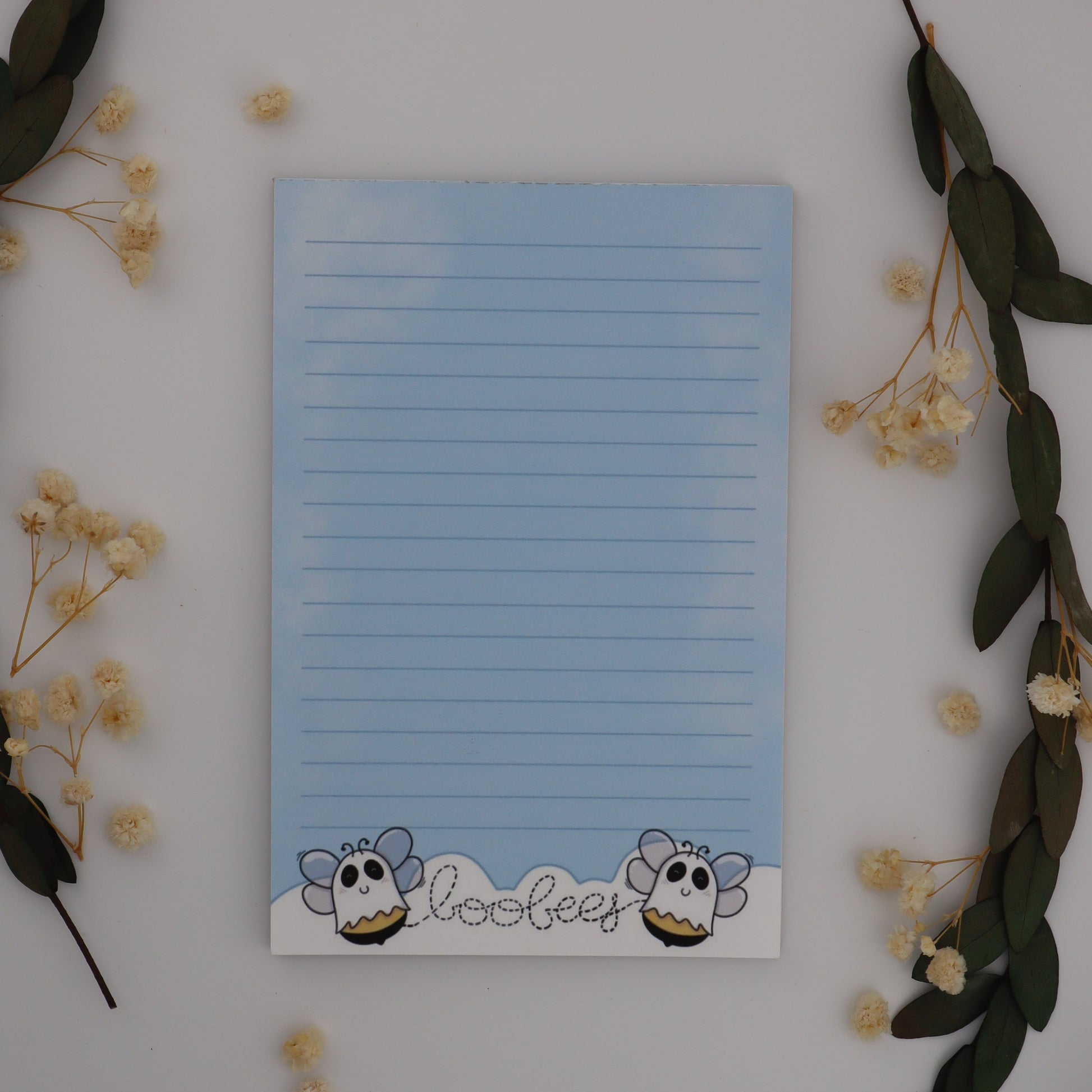 Notepad with cartoon character design on a white surface with decorative elements