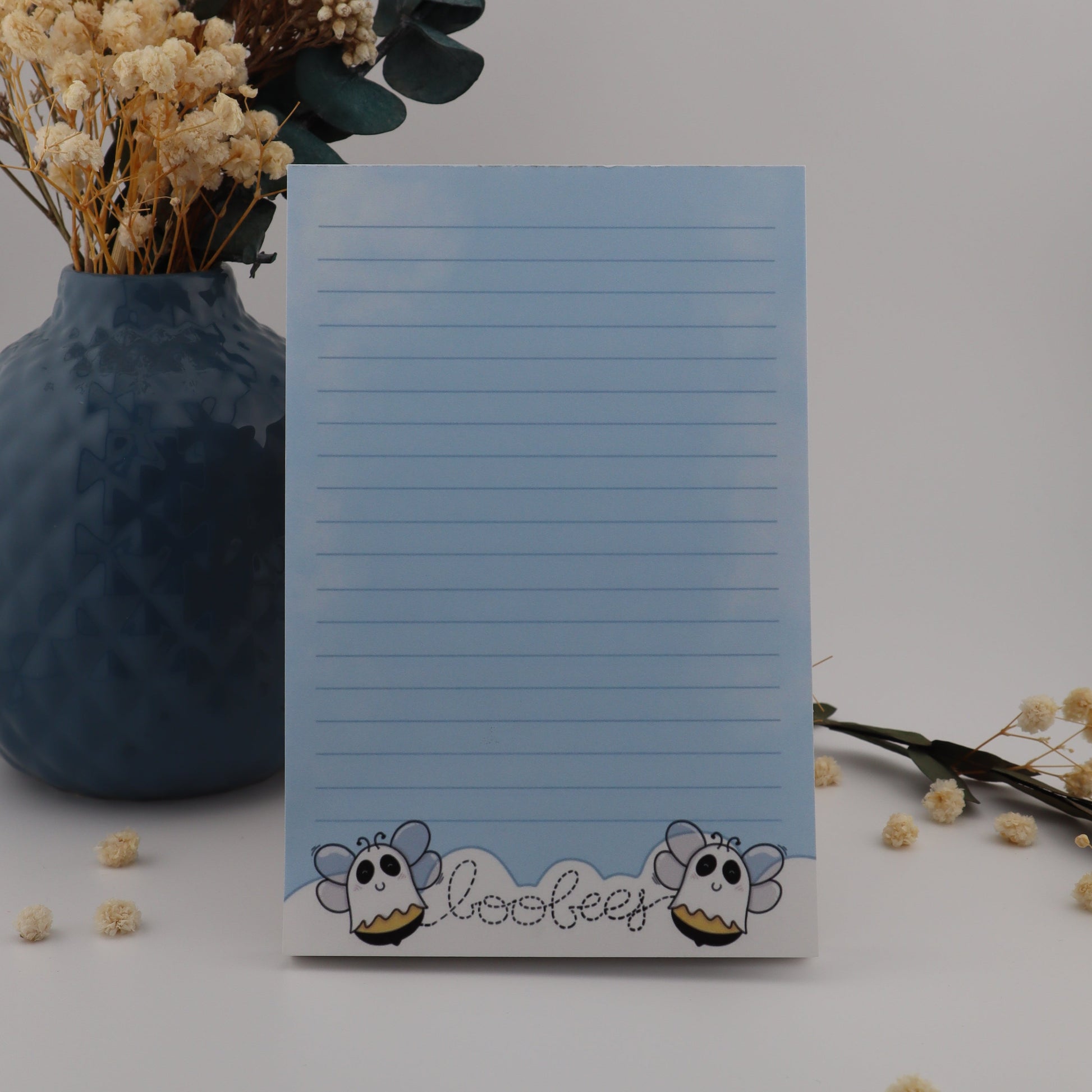 Notepad with cartoon character design on a white surface with decorative elements